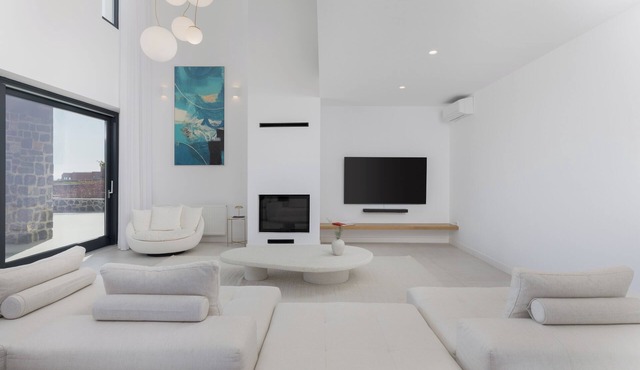 A luxurious Santorini villa set in a vineyard, with pool and stunning views.